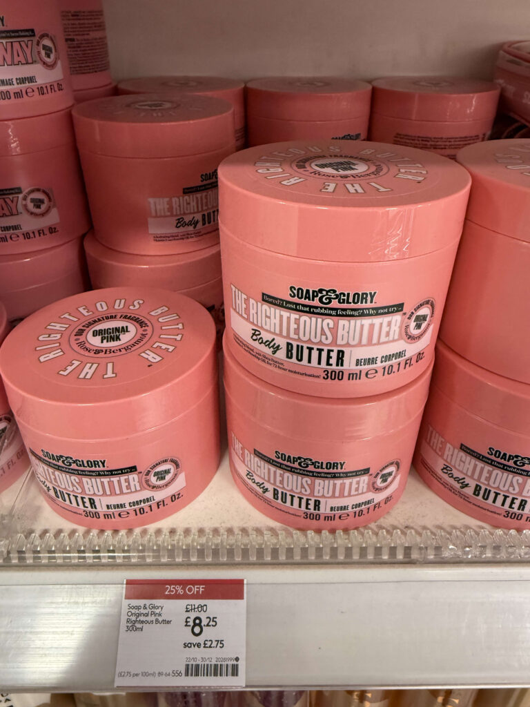 棚に積み上げられたピンク色の容器のSoap & Gloryボディバターと25%オフの価格タグ