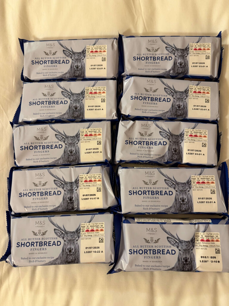 Eight packs of M&S All Butter Scottish Shortbread Fingers arranged in two columns, featuring a stag illustration on the packaging.