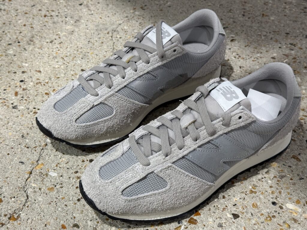 Gray New Balance 471 sneakers from the JUNYA WATANABE MAN collaboration on a concrete floor