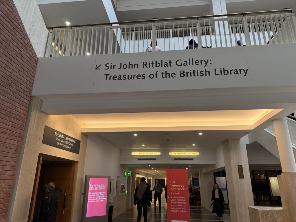 大英図書館内の「Sir John Ritblat Gallery: Treasures of the British Library」の入り口案内板と、その下の通路の様子