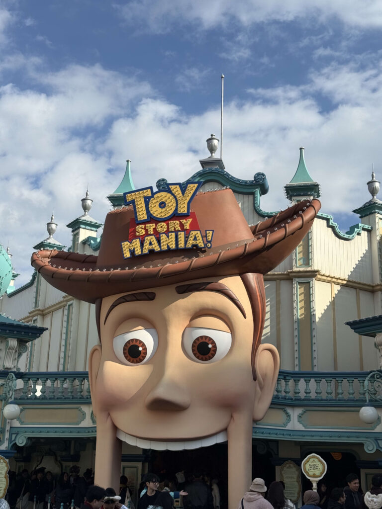 The giant Woody head entrance of the Toy Story Mania attraction under a blue sky