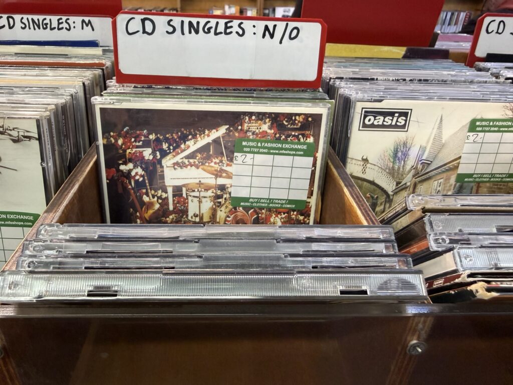 「CD SINGLES : N / O」という仕切りのある棚に並べられたOasisのシングルCD