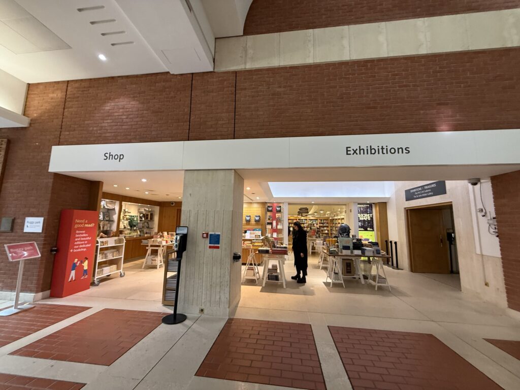 赤いレンガの壁に「Shop」と「Exhibitions」の看板がある建物内のショップと展示室の入り口