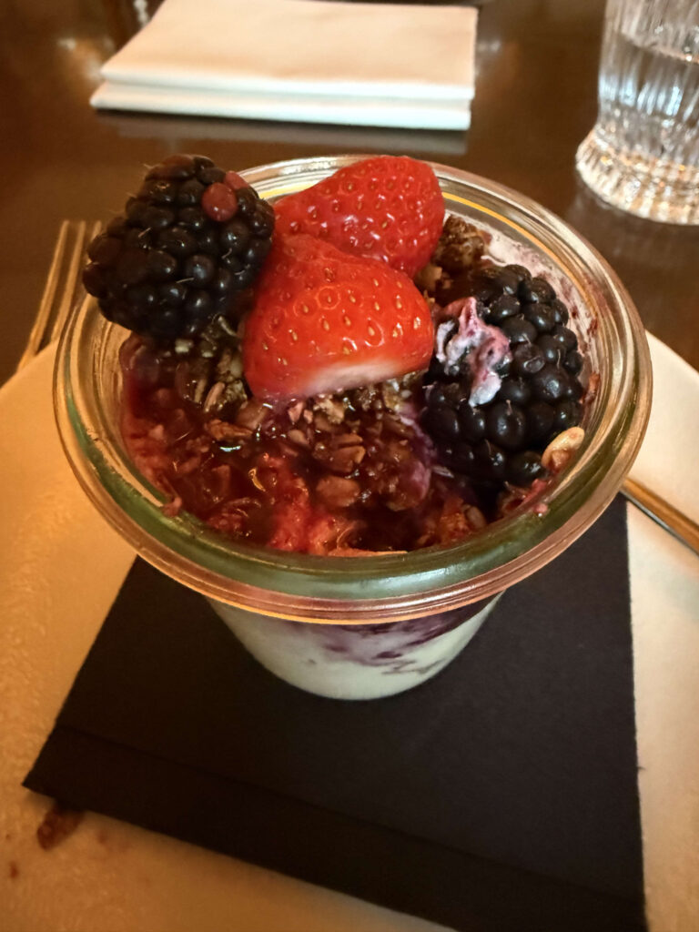 イチゴとブラックベリー、グラノーラがトッピングされたガラス瓶入りのギリシャヨーグルト