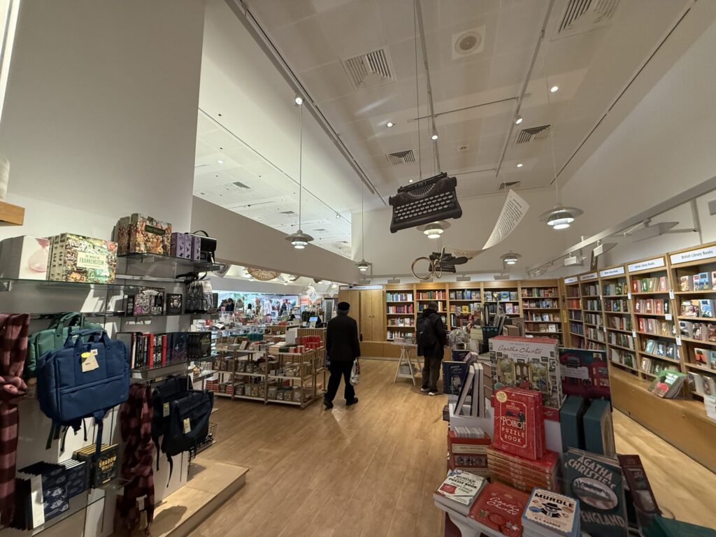 大英図書館内のギフトショップ。本棚や雑貨が並び、天井には巨大なタイプライターの装飾が吊るされている
