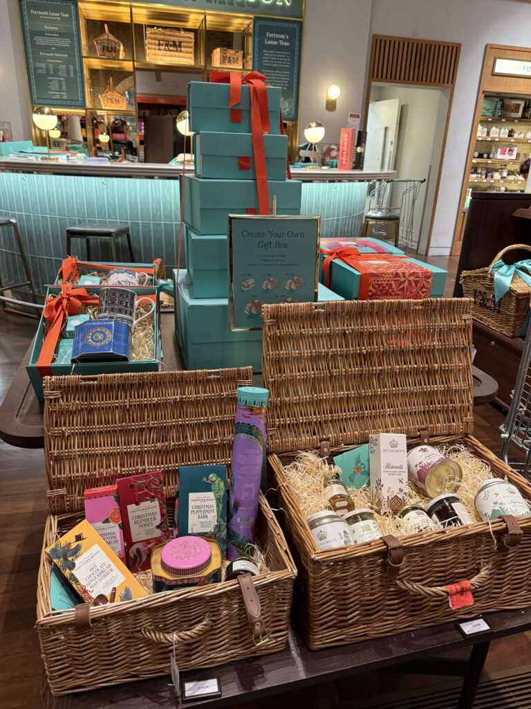 フォートナム・アンド・メイソンの「Create Your Own Gift Box」コーナー。特製の籐のハンパーと積み上げられた水色のギフトボックス。
