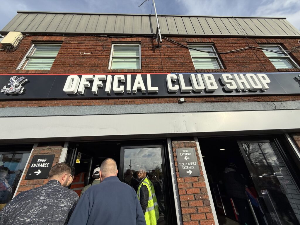 Exterior of the Crystal Palace FC Official Club Shop with fans queuing at the entrance