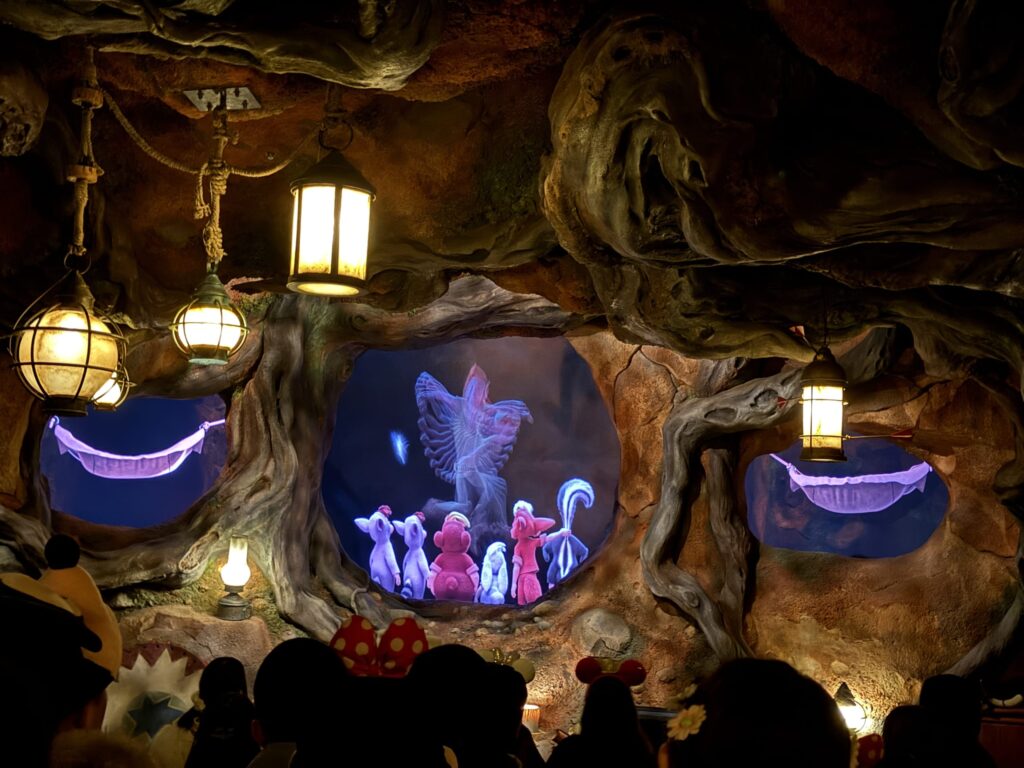 Interior view of the Splash Mountain ride showing a dimly lit cave scene with hanging lanterns and animal characters
