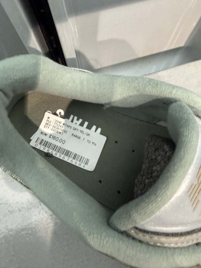 Price sticker of 160 GBP on the insole of a WTAPS collaboration sneaker showing model details