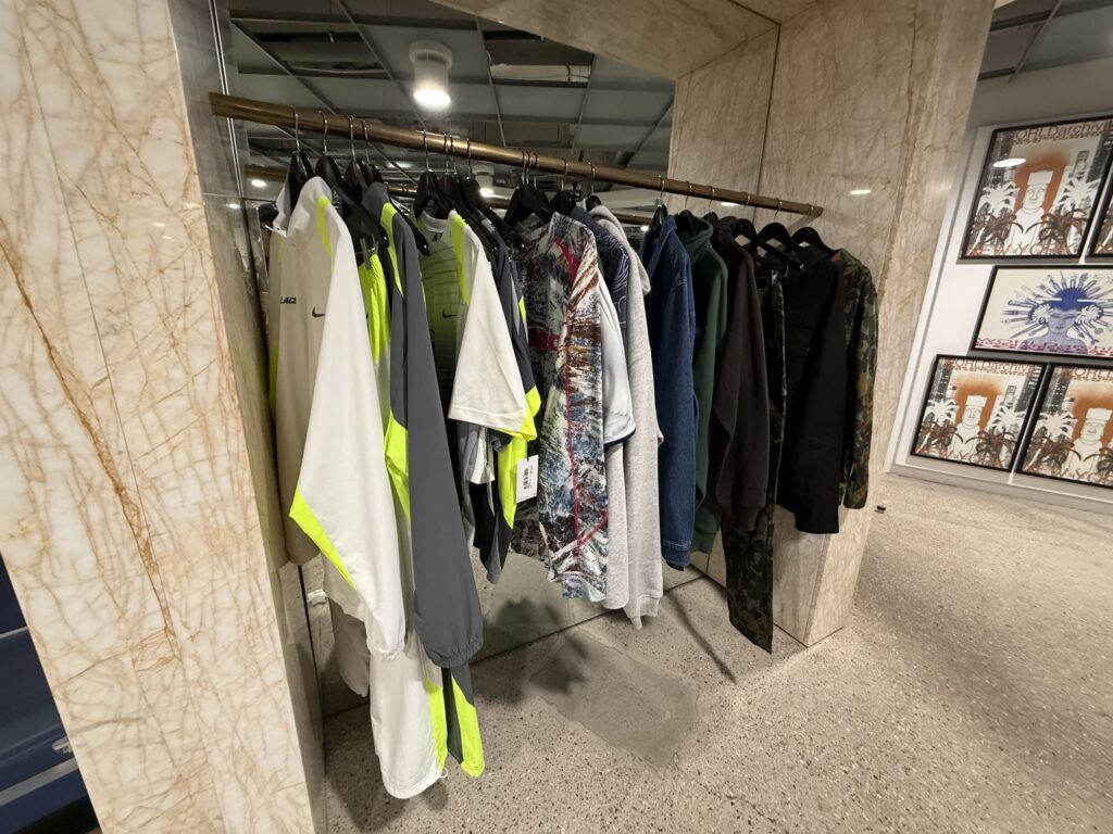 Nike and Palace collaboration clothing hanging on a rack inside a store with marble-patterned walls