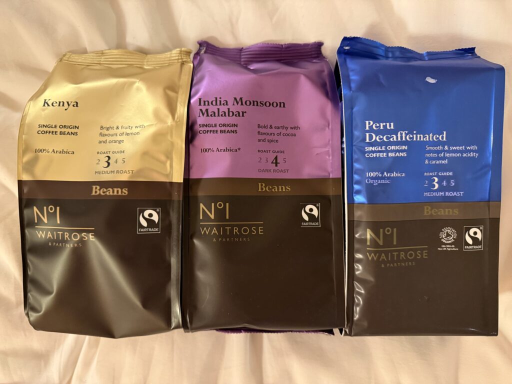 Three bags of Waitrose & Partners No.1 Single Origin coffee beans: Kenya, India Monsoon Malabar, and Peru Decaffeinated.