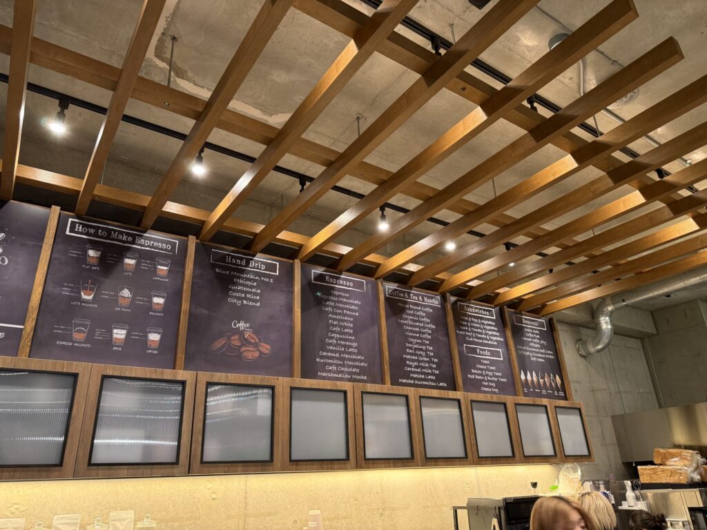 Cafe interior featuring a wooden grid ceiling and large chalkboard menu boards