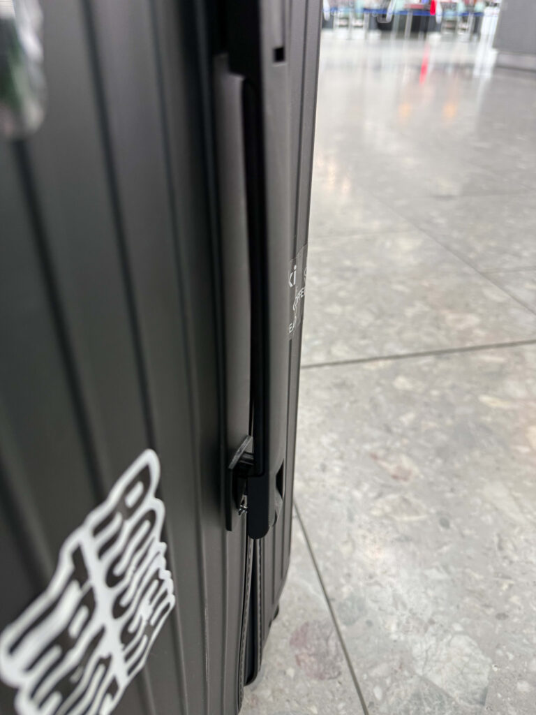 黒いリモワのスーツケースの側面ハンドルが外れて壊れている様子