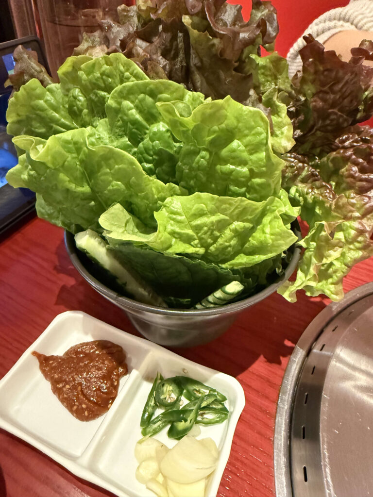 焼肉用の新鮮なサンチュとサニーレタスの盛り合わせ、特製味噌、青唐辛子、ニンニクの薬味皿