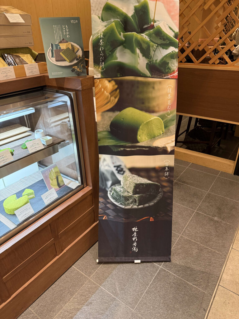 林屋新兵衛の店頭タペストリーとショーケース。抹茶わらび餅、抹茶葛ねり、百年餅の写真が大きく掲載されている