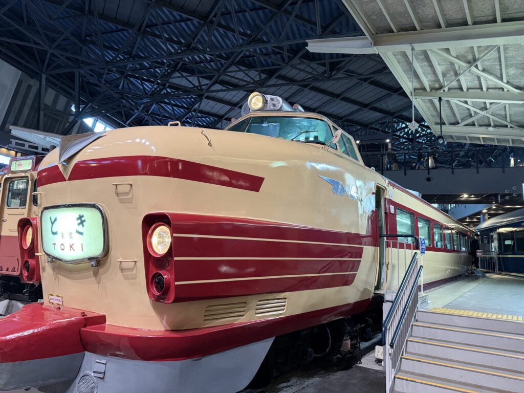 Cream and red JNR 181 series limited express train 'Toki' with a bonnet-style nose displayed indoors