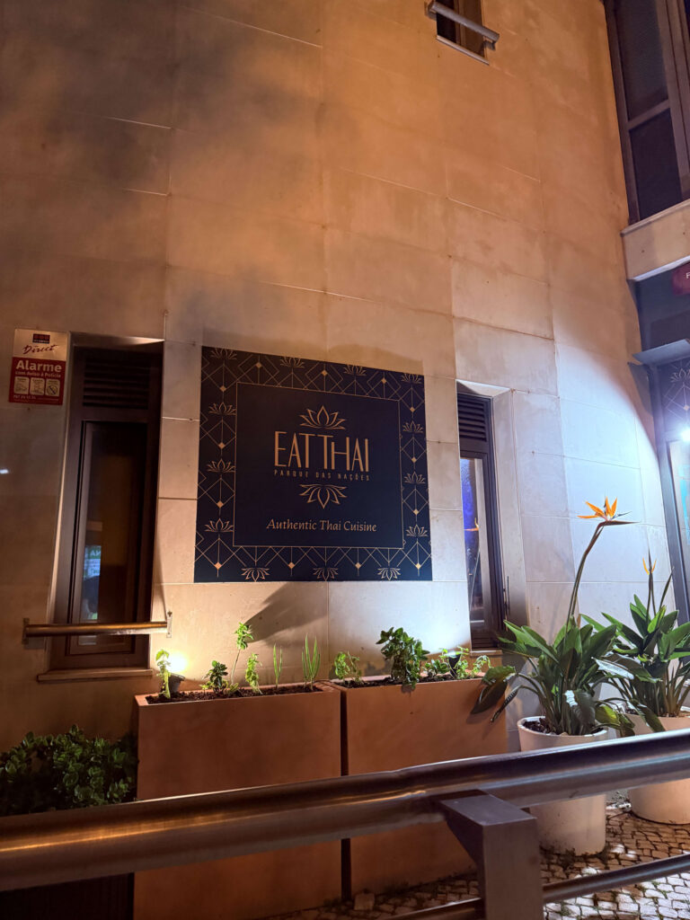 リスボンのパルケ・ダス・ナソンイス地区にあるタイ料理レストラン「Eat Thai」の、夜のライトアップされた外観と看板
