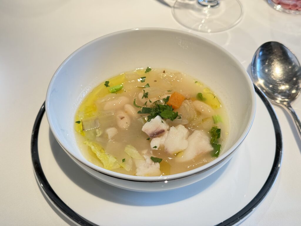 白いボウルに盛られた真鱈と白インゲン豆のミネストローネスープ