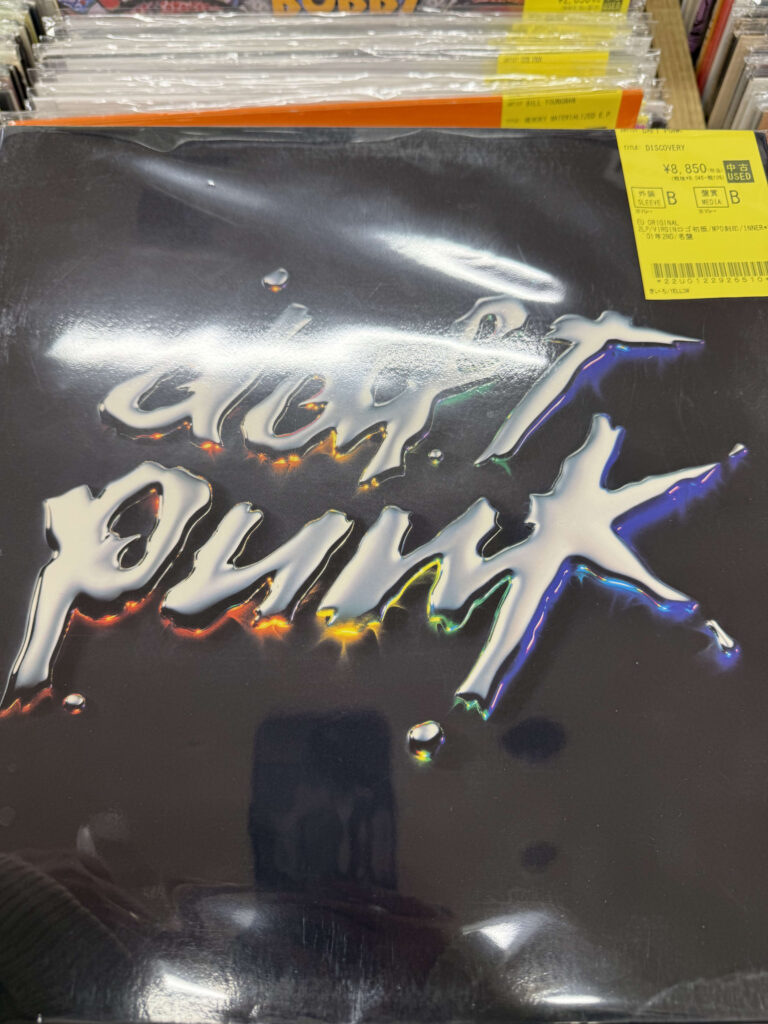 Vinyl record cover of Daft Punk's album 'Discovery' featuring a metallic logo on a black background with a yellow price sticker in the top right corner.