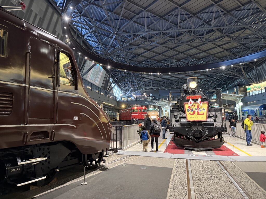 鉄道博物館で展示されている茶色の流線型電気機関車EF55形と、転車台に乗った蒸気機関車C57形