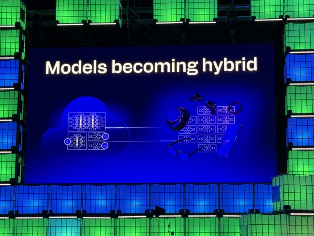 Presentation slide titled 'Models becoming hybrid' showing a diagram connecting a cloud icon to wearable devices.