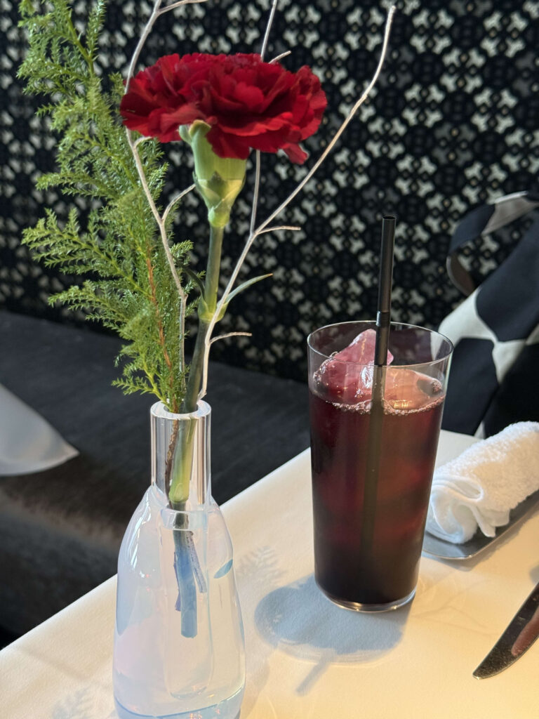 赤いカーネーションの一輪挿しと氷が入ったアイスドリンク