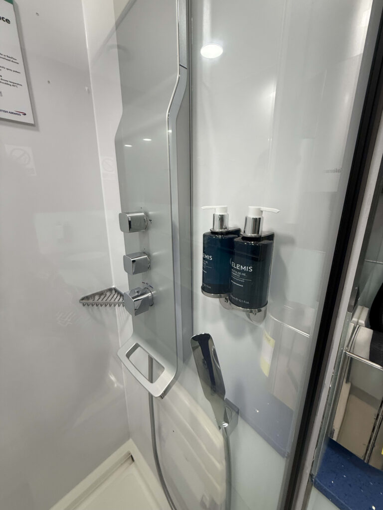 Elemis amenity dispensers and chrome shower controls in a British Airways shower room