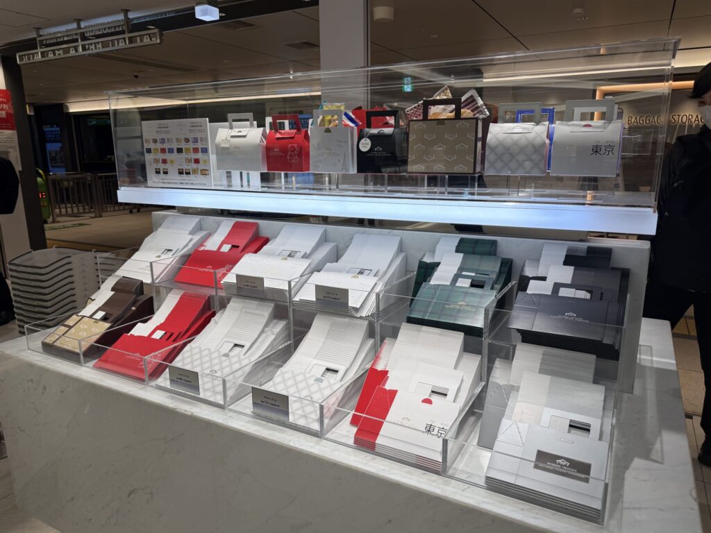 ガトーフェスタハラダの店舗に陳列された、多彩なデザインのギフト用プチバッグとボックスのディスプレイ