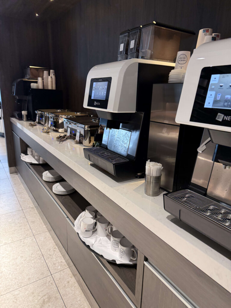 Commercial coffee machines and hot food chafing dishes at a hotel buffet counter