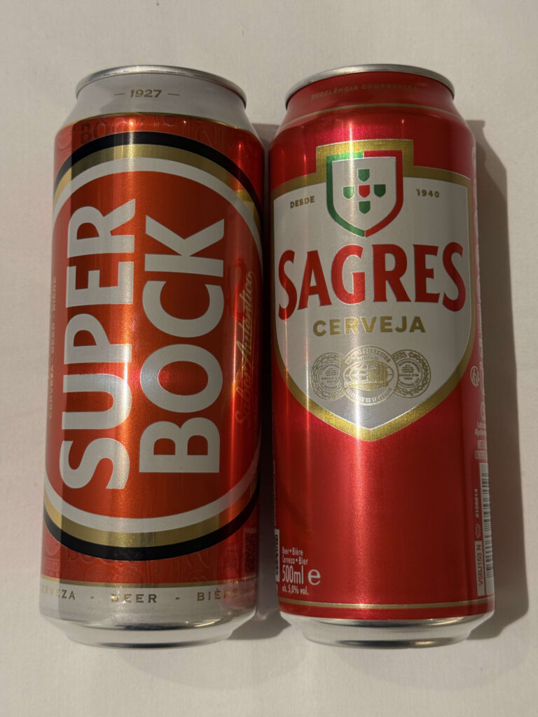Two Portuguese beer cans standing side by side against a white background, Super Bock on the left and Sagres on the right