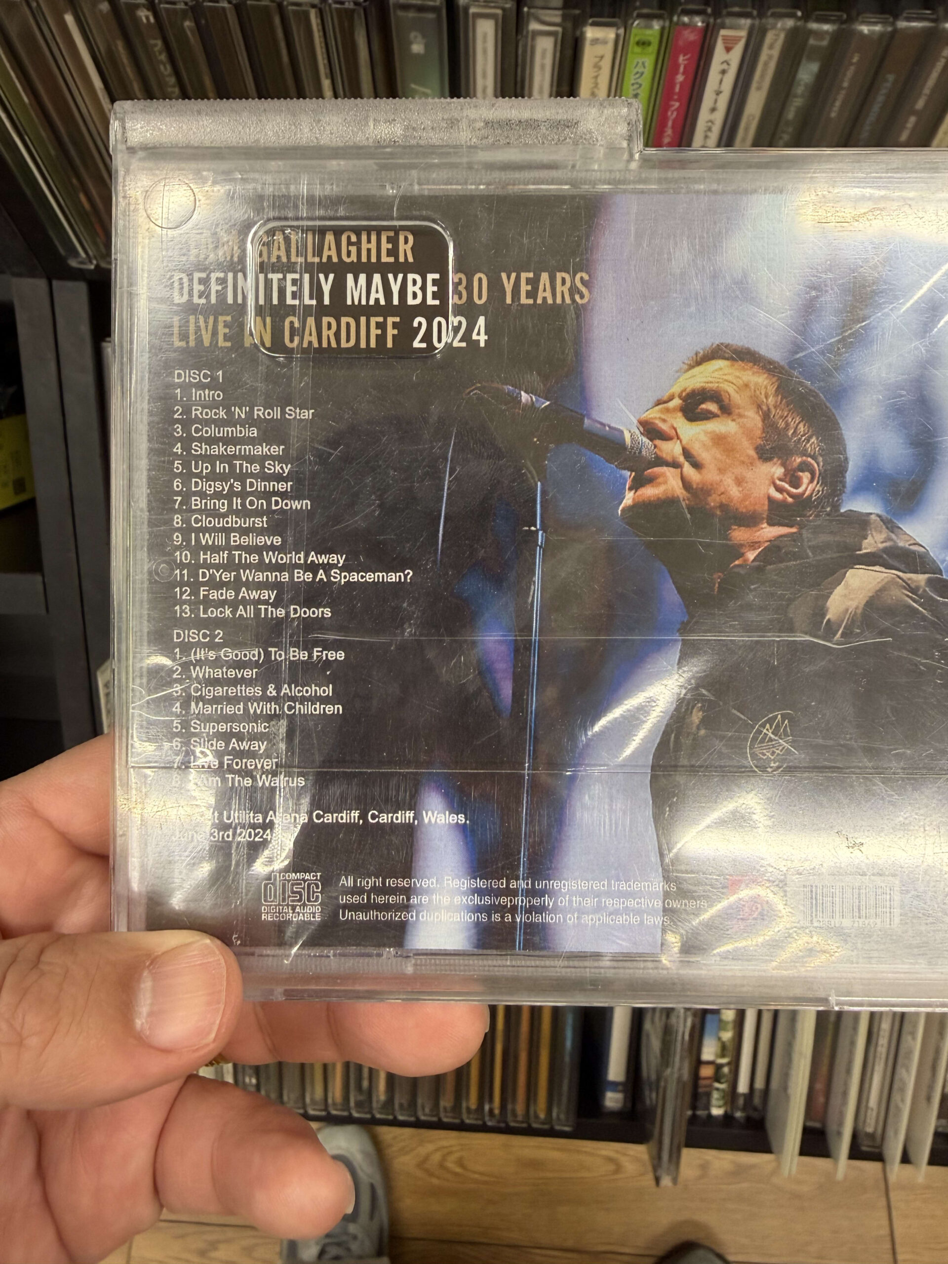 手に持ったリアム・ギャラガーのCD「DEFINITELY MAYBE 30 YEARS LIVE IN CARDIFF 2024」の裏面ジャケット