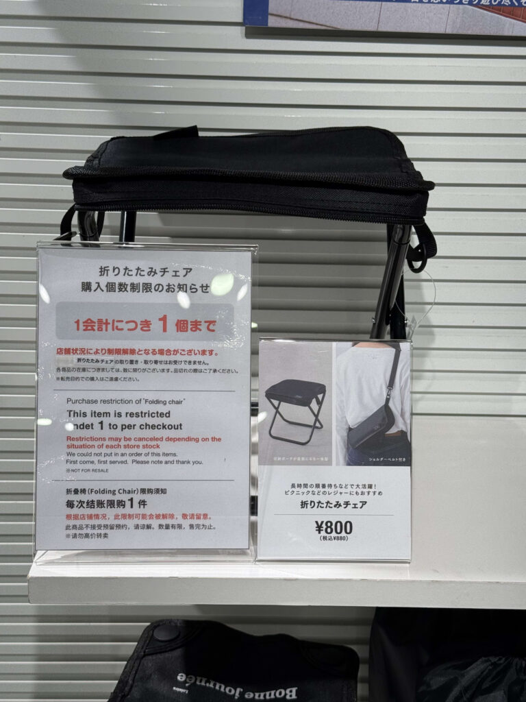 陳列棚に置かれた黒い折りたたみチェアと「1会計につき1個まで」の購入制限を知らせるポップ