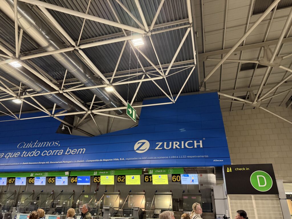 空港のチェックインカウンターDゾーンとZURICHの青い看板