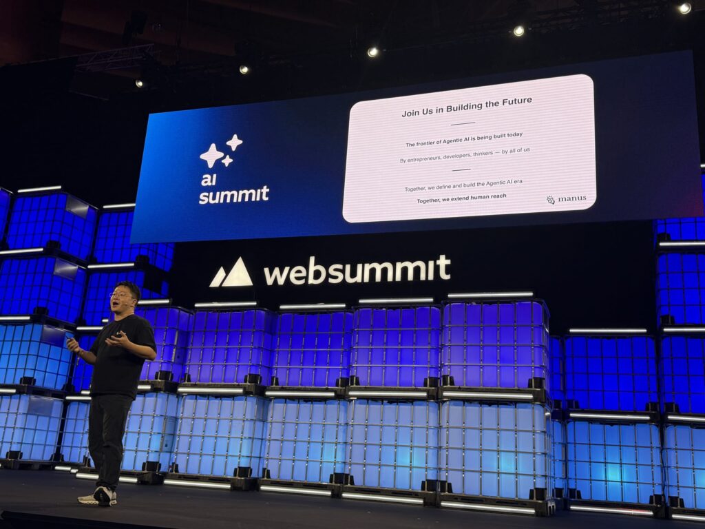 Speaker at Web Summit's AI Summit presenting a Manus slide titled 'Join Us in Building the Future' regarding Agentic AI