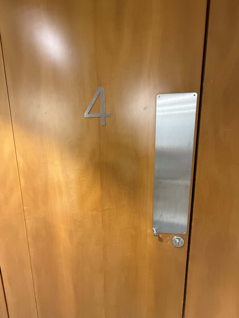 番号4が表示された木製のシャワー室のドア