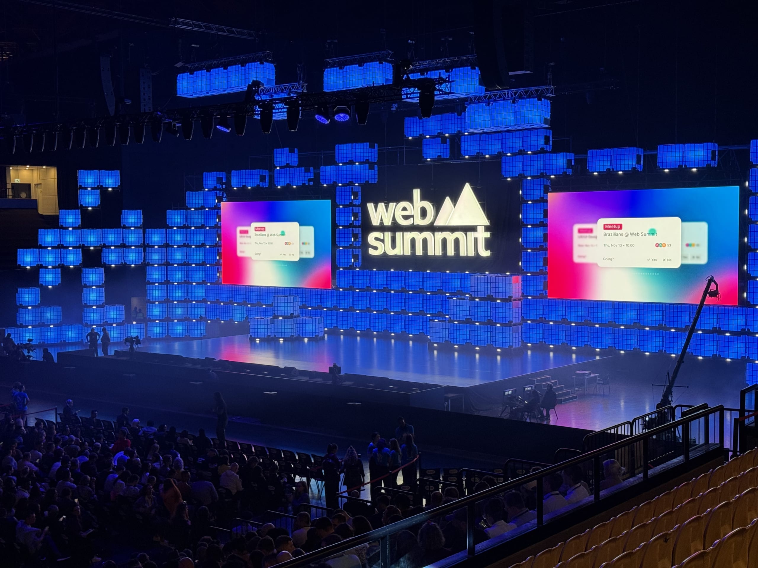 The Web Summit Centre Stage illuminated by blue cubic LED lights with a large audience in the foreground during opening night