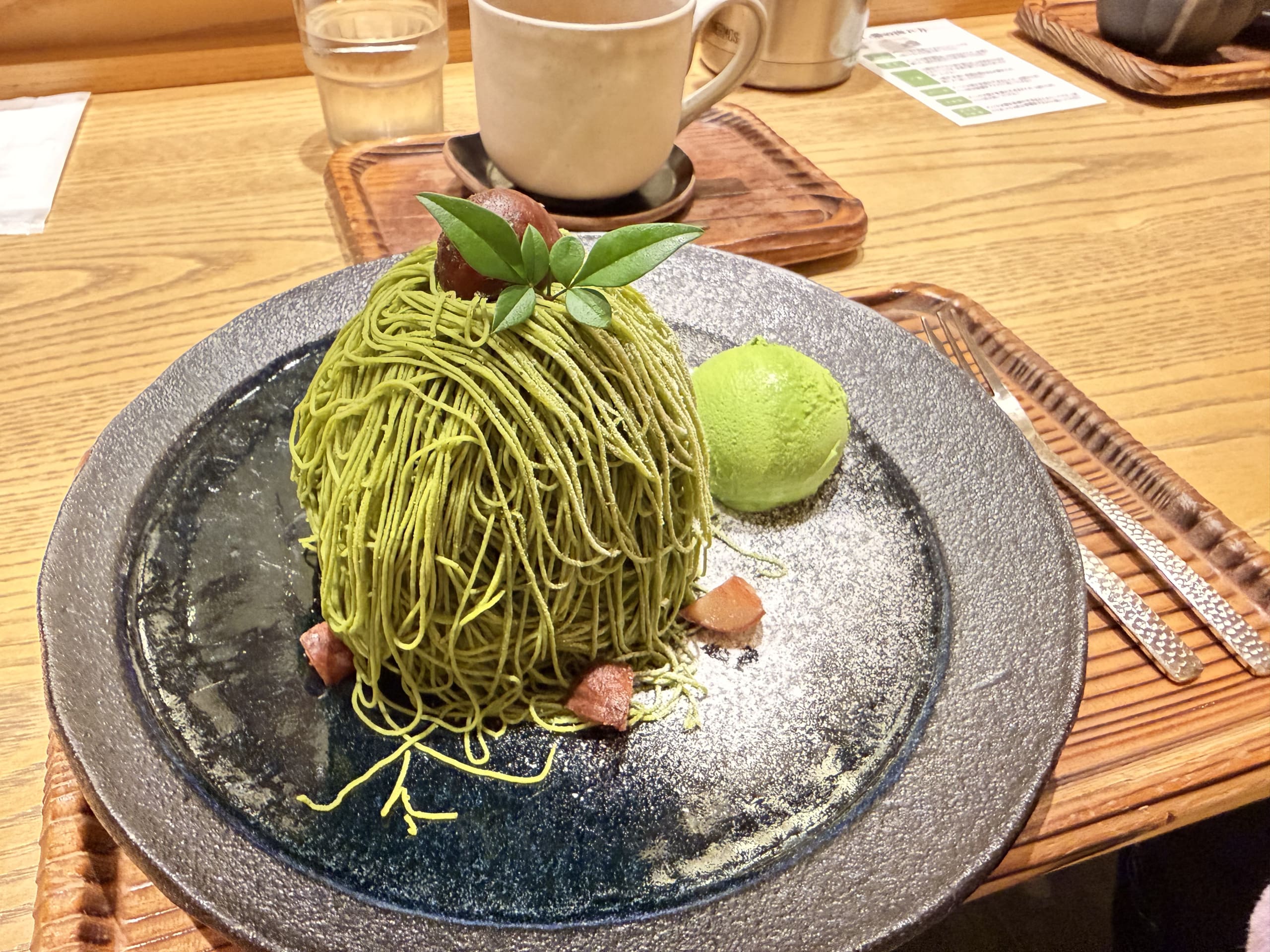 黒い皿に盛り付けられた抹茶の和モンブランと抹茶アイスクリーム、栗のトッピング