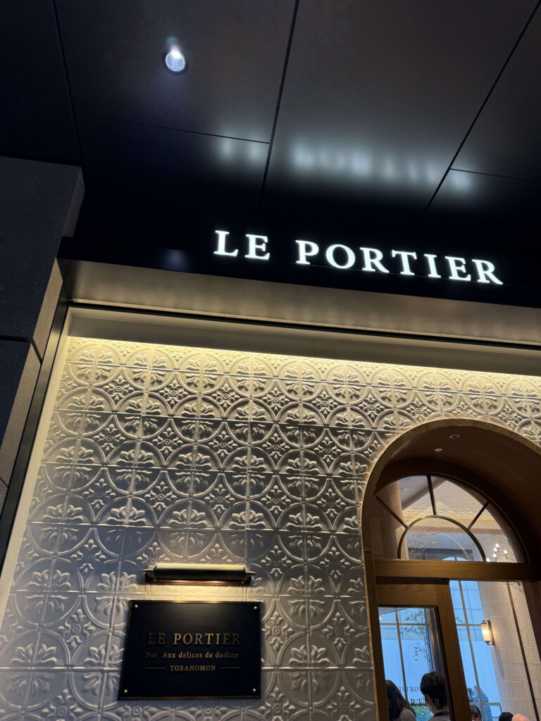 西新橋のビストロ「LE PORTIER（ル ポルティエ）」の白いレリーフ壁と黒い看板が特徴的な外観