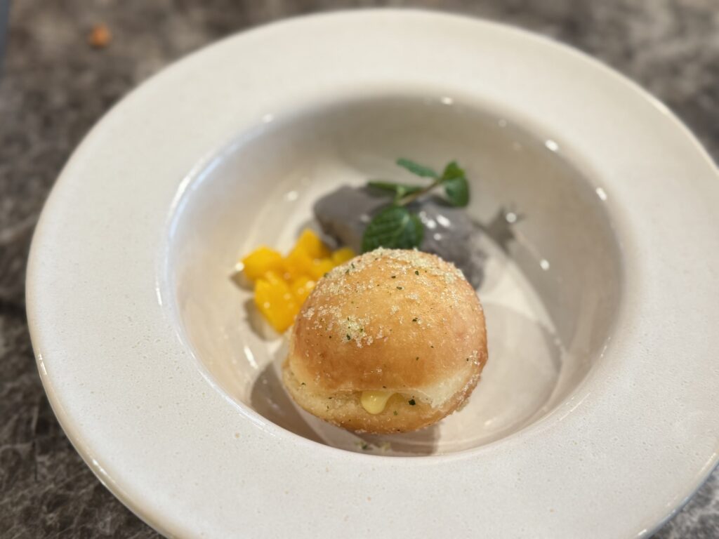 Lilikoi Malasada dessert plate with black ice cream and passion fruit cream