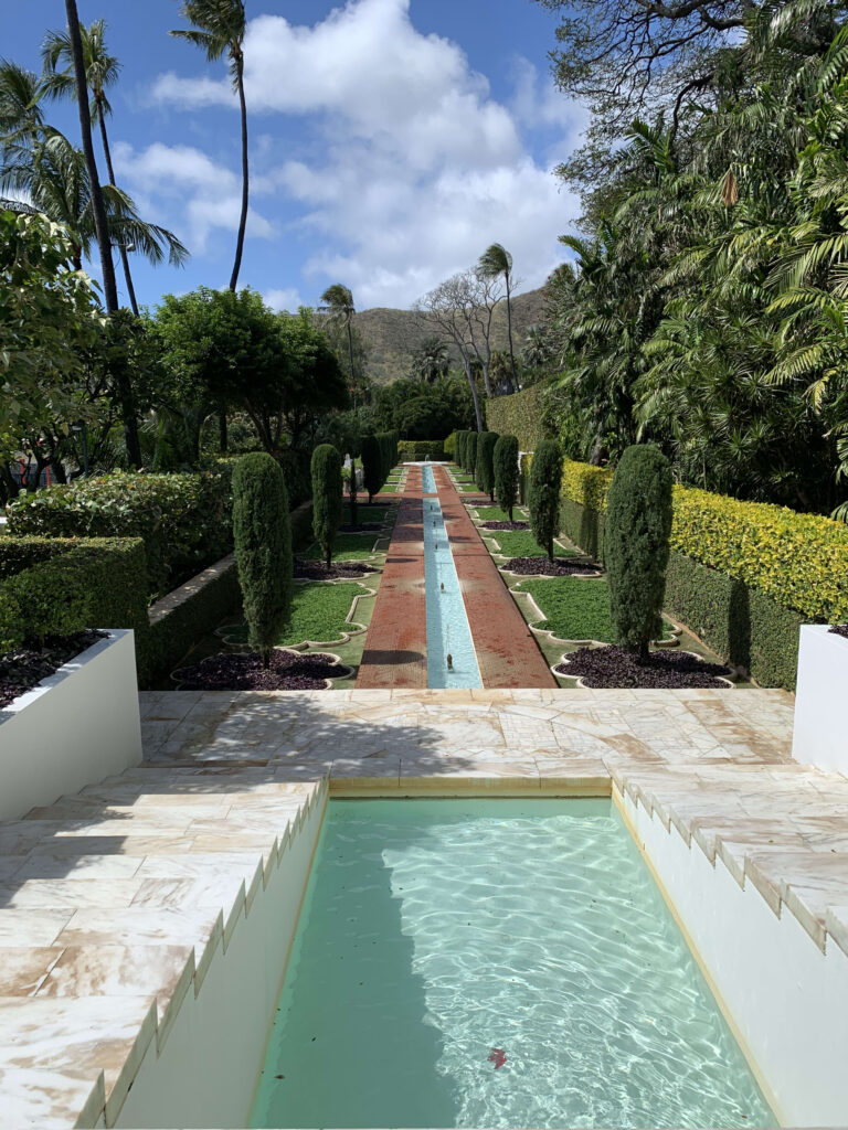 青空の下、大理石の階段から遠くの山へと続く長い水路と整形式の植栽が美しいムガル・ガーデン