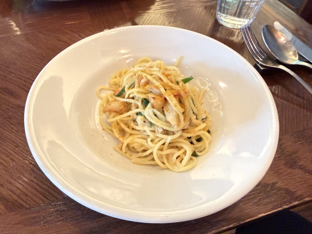 白い皿に盛られたズワイガニとカラスミのアーリオオーリオパスタ