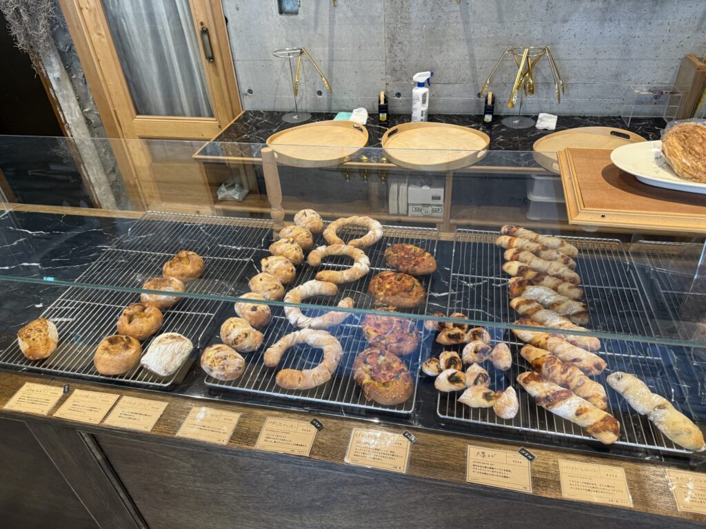 Hard breads and savory pastries displayed in a bakery glass case