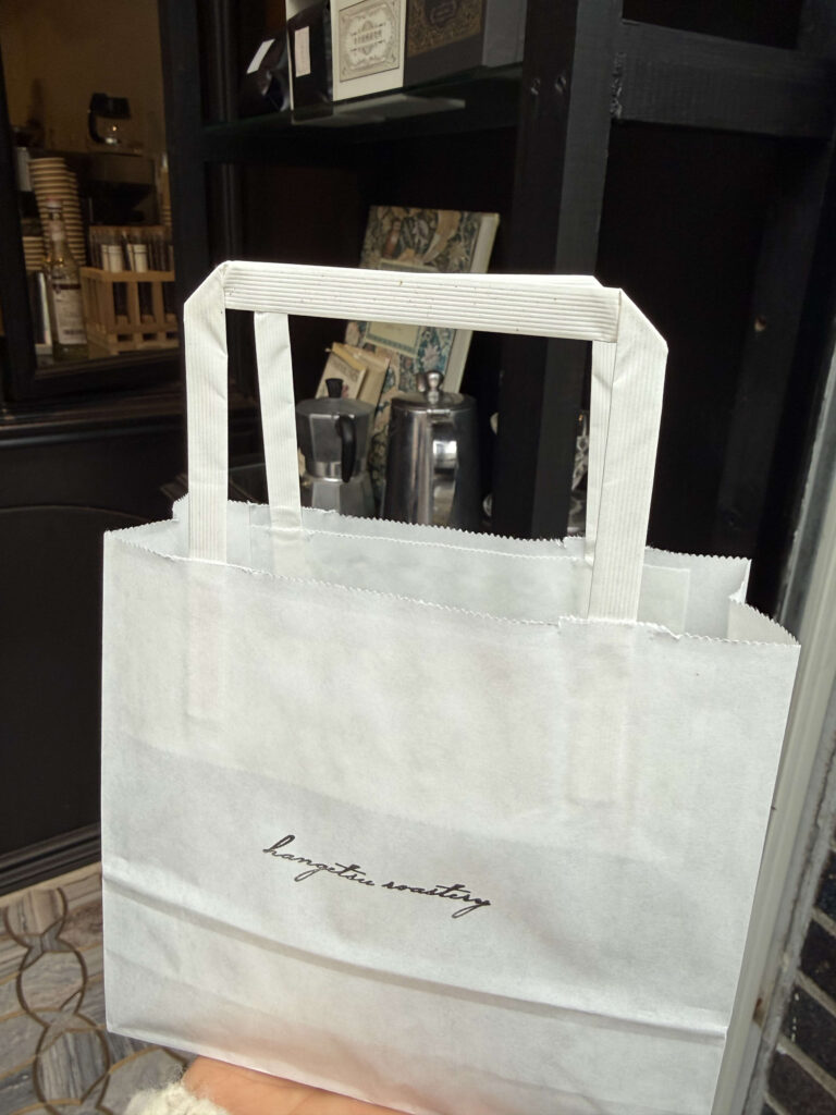 「hangetsu roastery」の筆記体ロゴが入った白いテイクアウト用紙袋