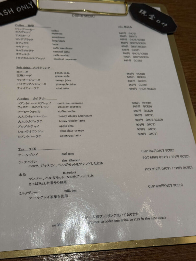 クリップボードに挟まれたカフェのドリンクメニュー表と「現金のみ」のタグ