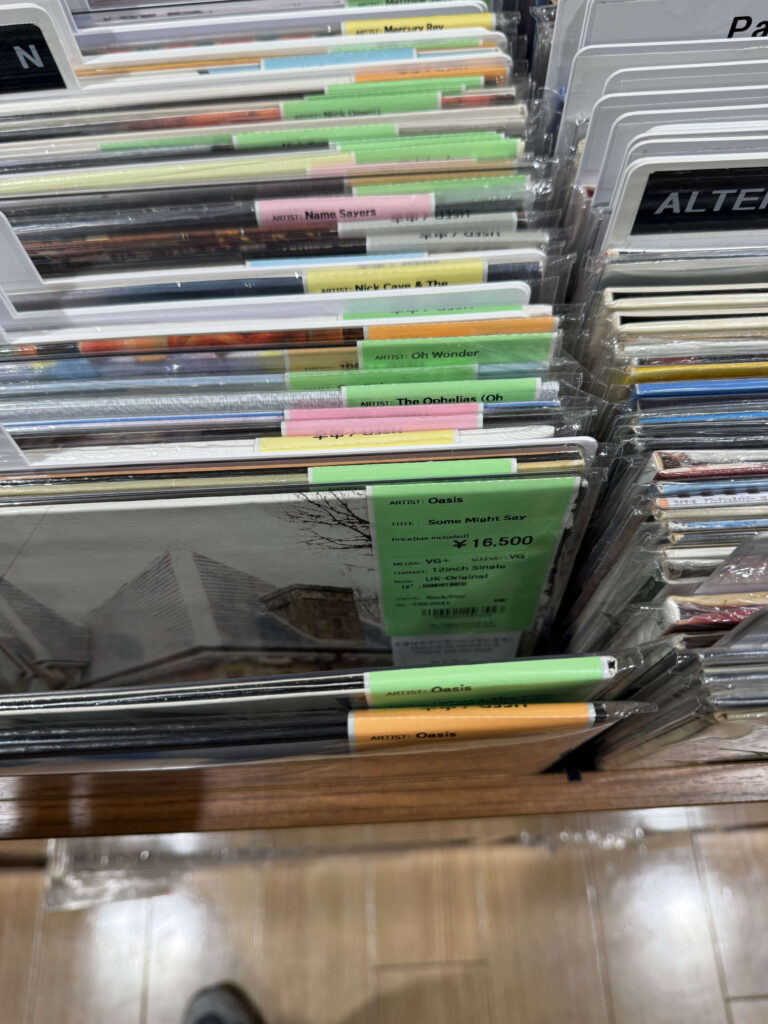 Display bin in a record store featuring a UK original pressing of Oasis 'Some Might Say' 12-inch single