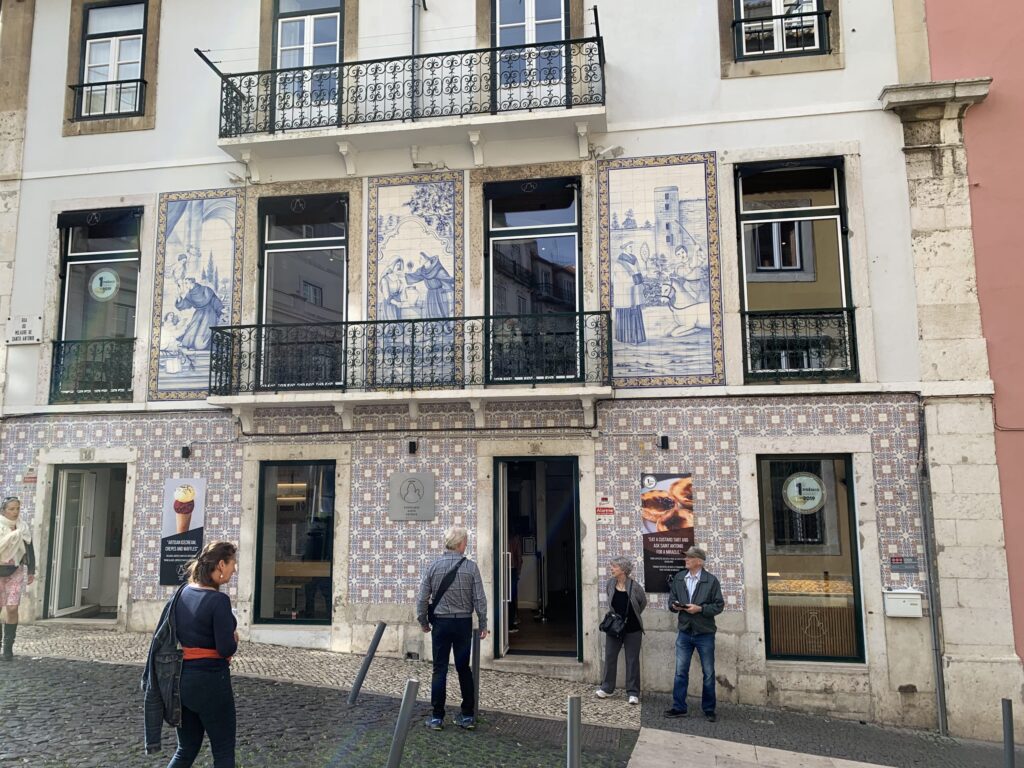 Facade of Pastelaria Santo António in Lisbon, decorated with elaborate blue and white Azulejo tile panels and iron balconies