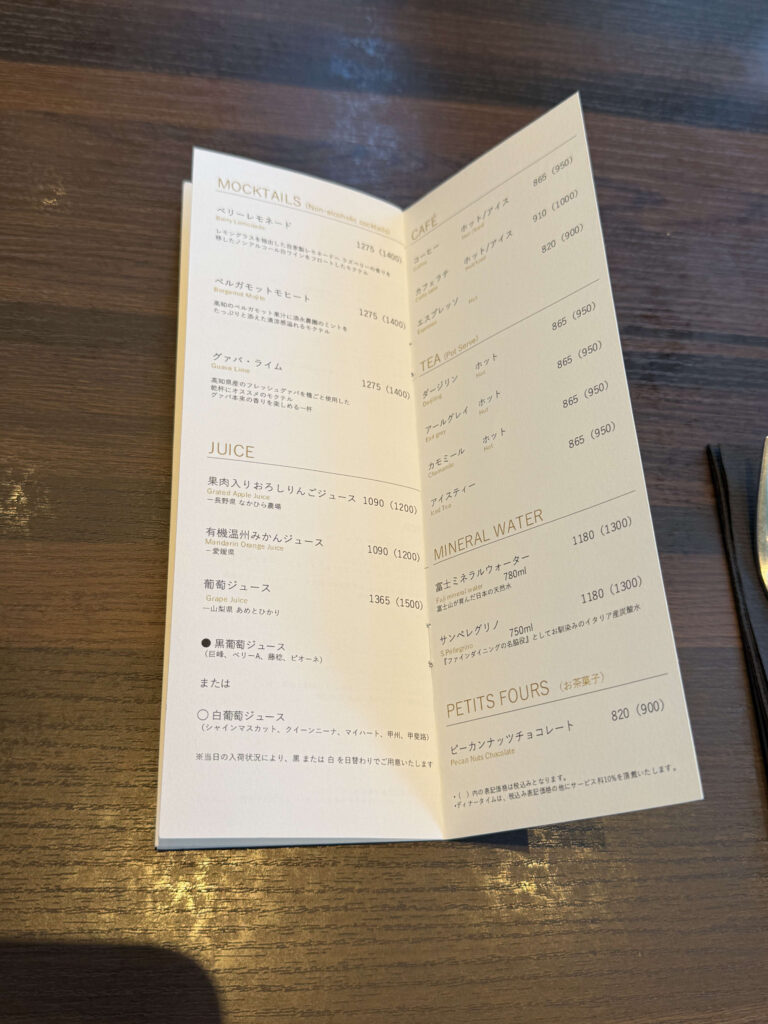 木目のテーブルに置かれたモクテルやカフェメニューが記載されたドリンクリスト