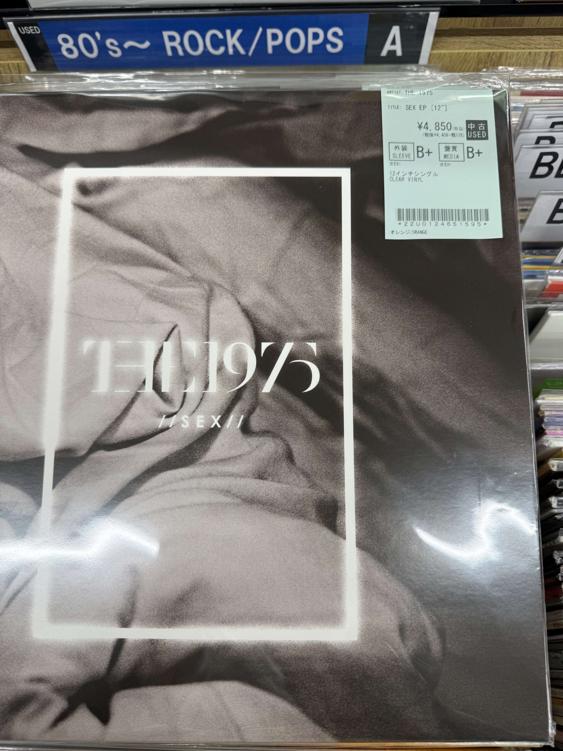 Cover art of The 1975's 'Sex EP' 12-inch vinyl record, featuring a black and white image of crumpled sheets with a price sticker in the corner.