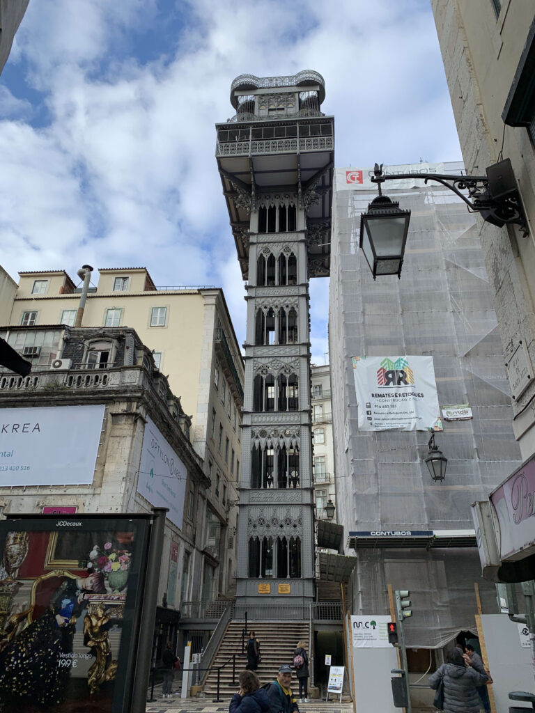 The Santa Justa Lift in Lisbon towering against a blue sky with delicate iron details