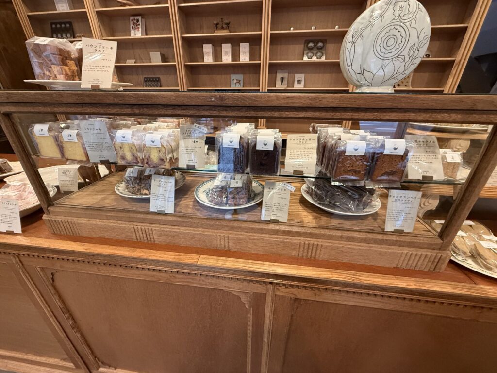 Baked goods such as pound cakes and brownies displayed in a wooden glass showcase